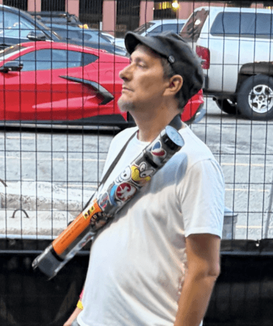 Fan carrying a poster tube away from the venue